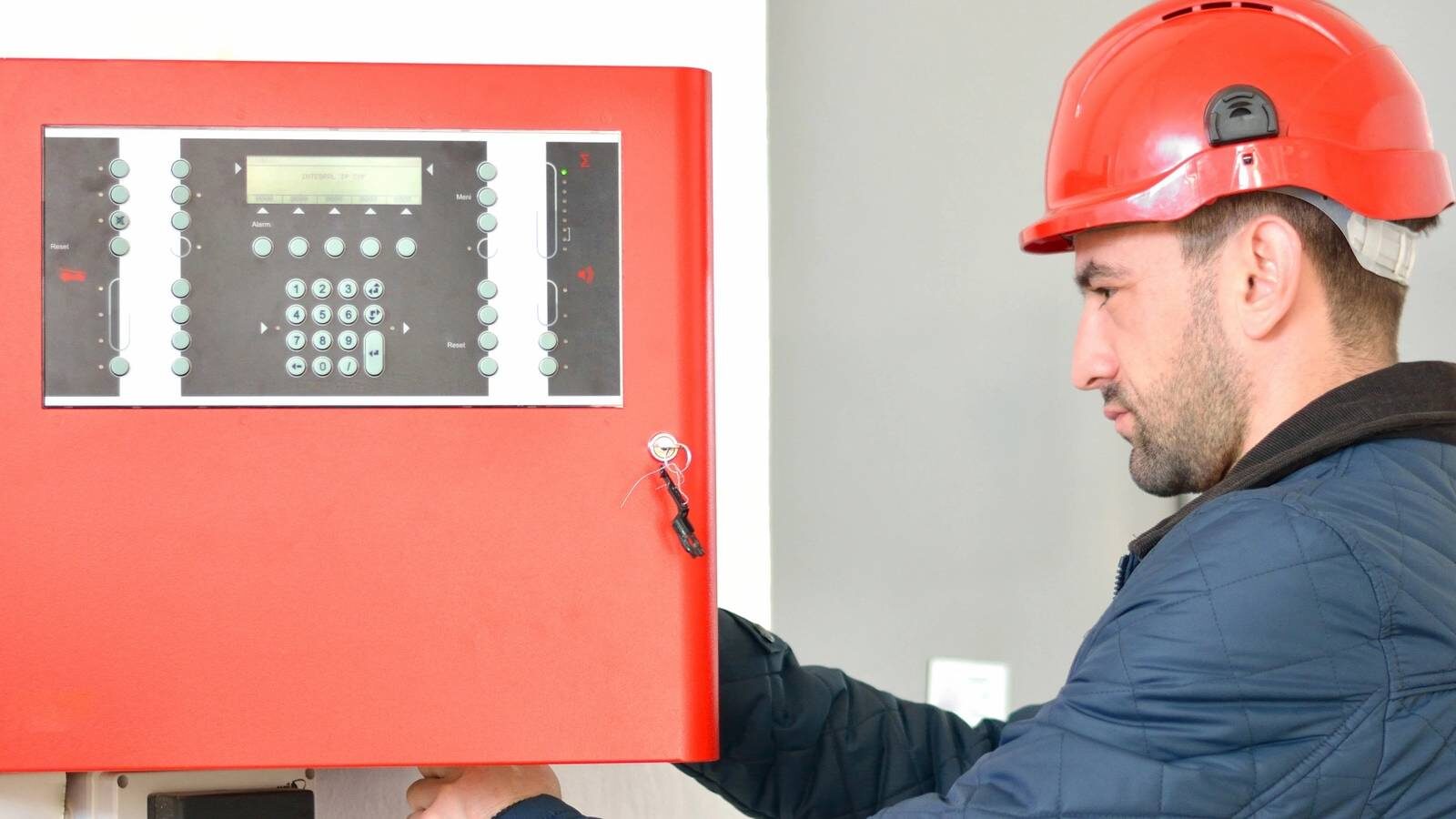 Technician working on a fire alarm panel.